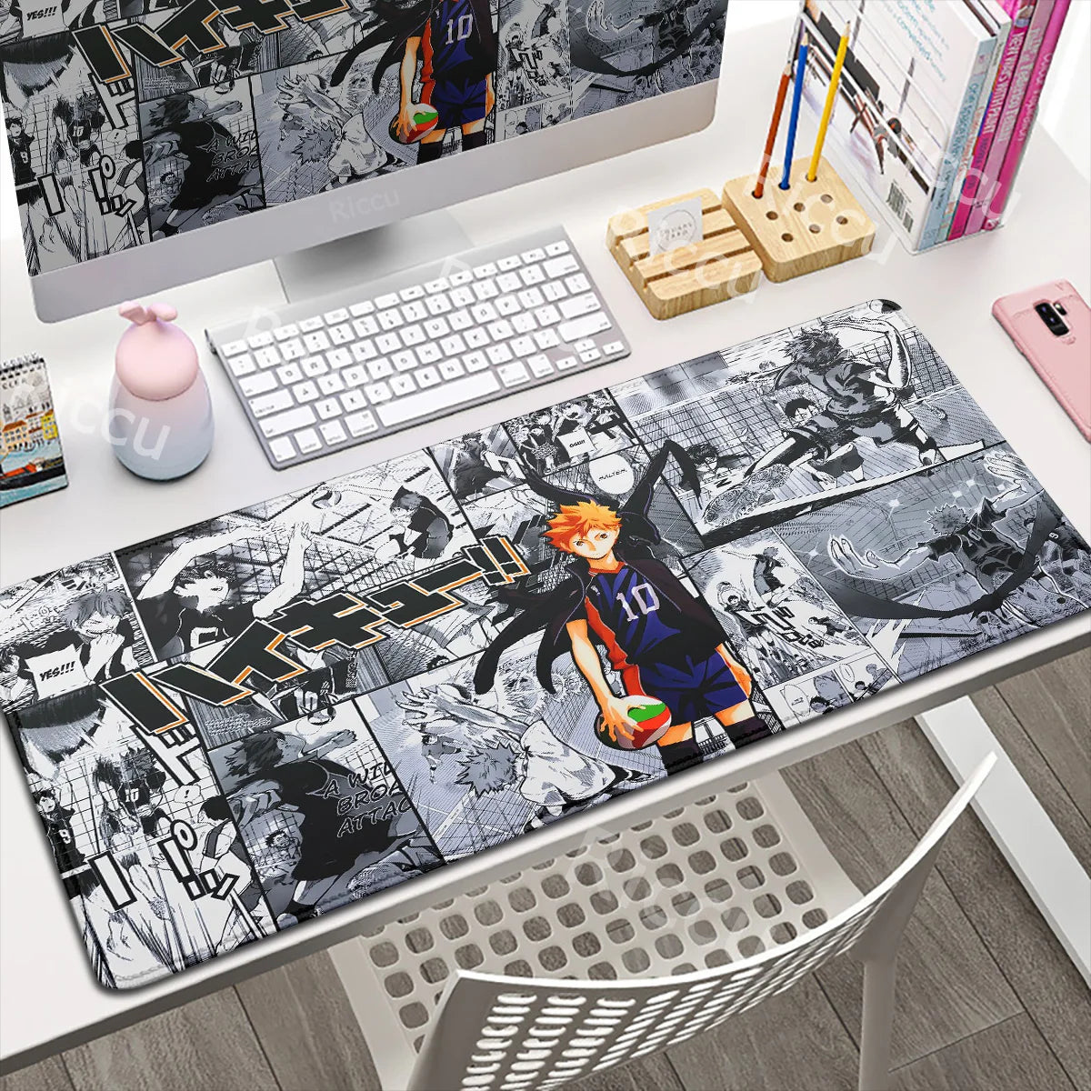 Desk setup with a large mouse pad featuring anime-style artwork, including a character in a sports uniform.