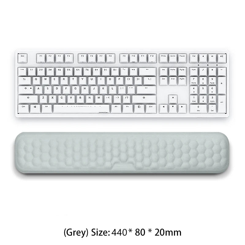 White keyboard with a large gray wrist rest on a white background