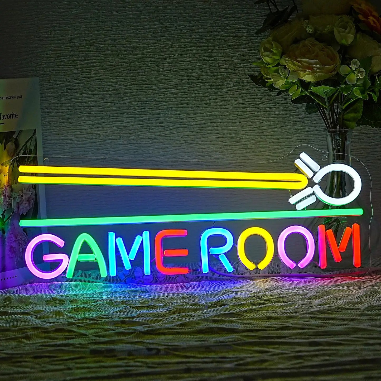 Neon sign with 'GAME ROOM' text and light saber design on a textured wall.