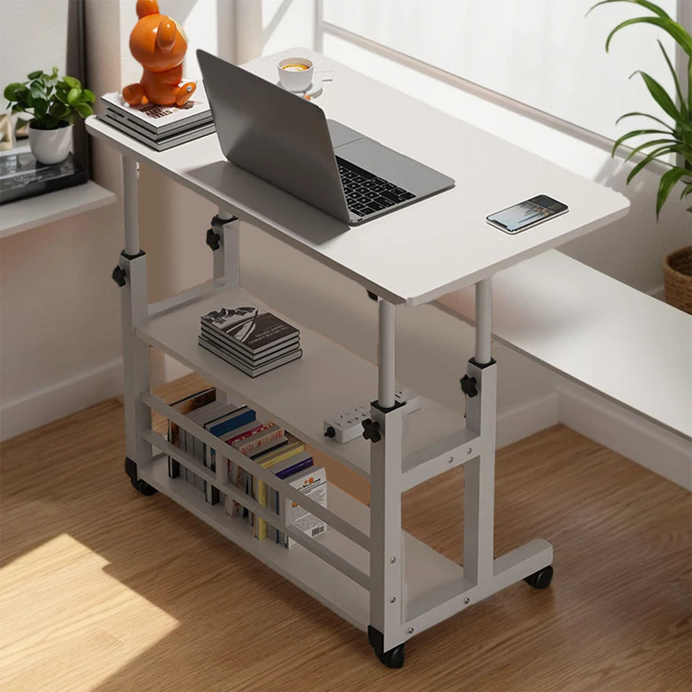 White adjustable desk with laptop, books, and a phone on a wooden floor.