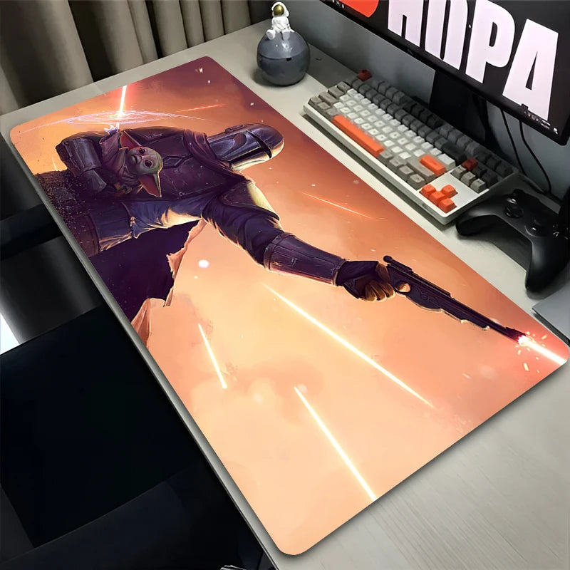 Desk setup with a large mouse pad featuring an action scene, keyboard, and monitor.