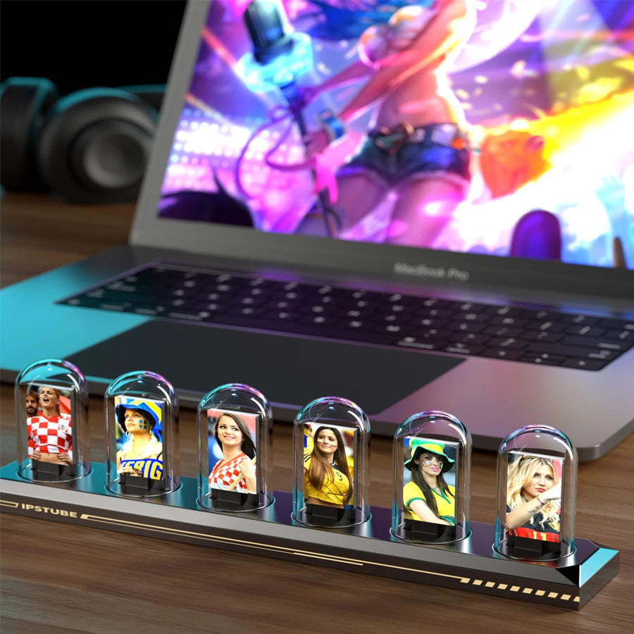 Laptop with a display of people in small glass domes on a wooden surface.