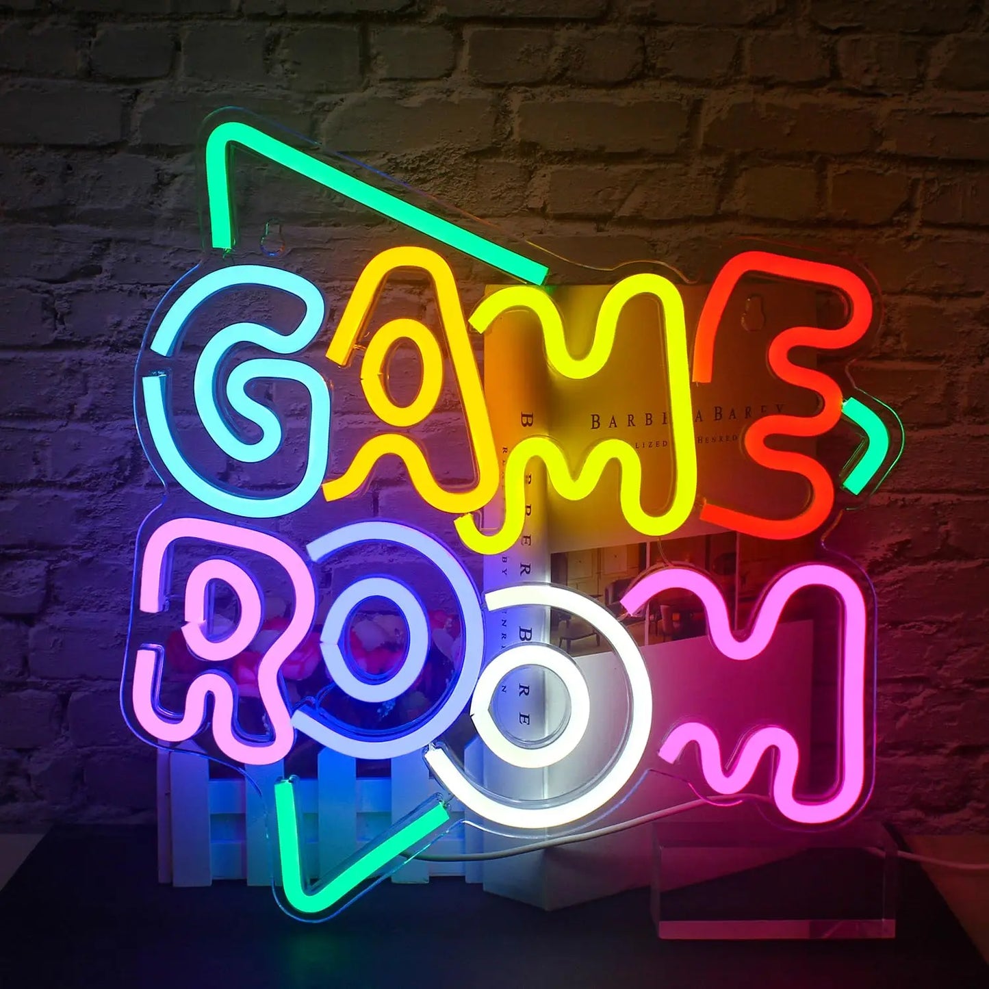 Neon sign with 'GAME ROOM' text on a brick wall background