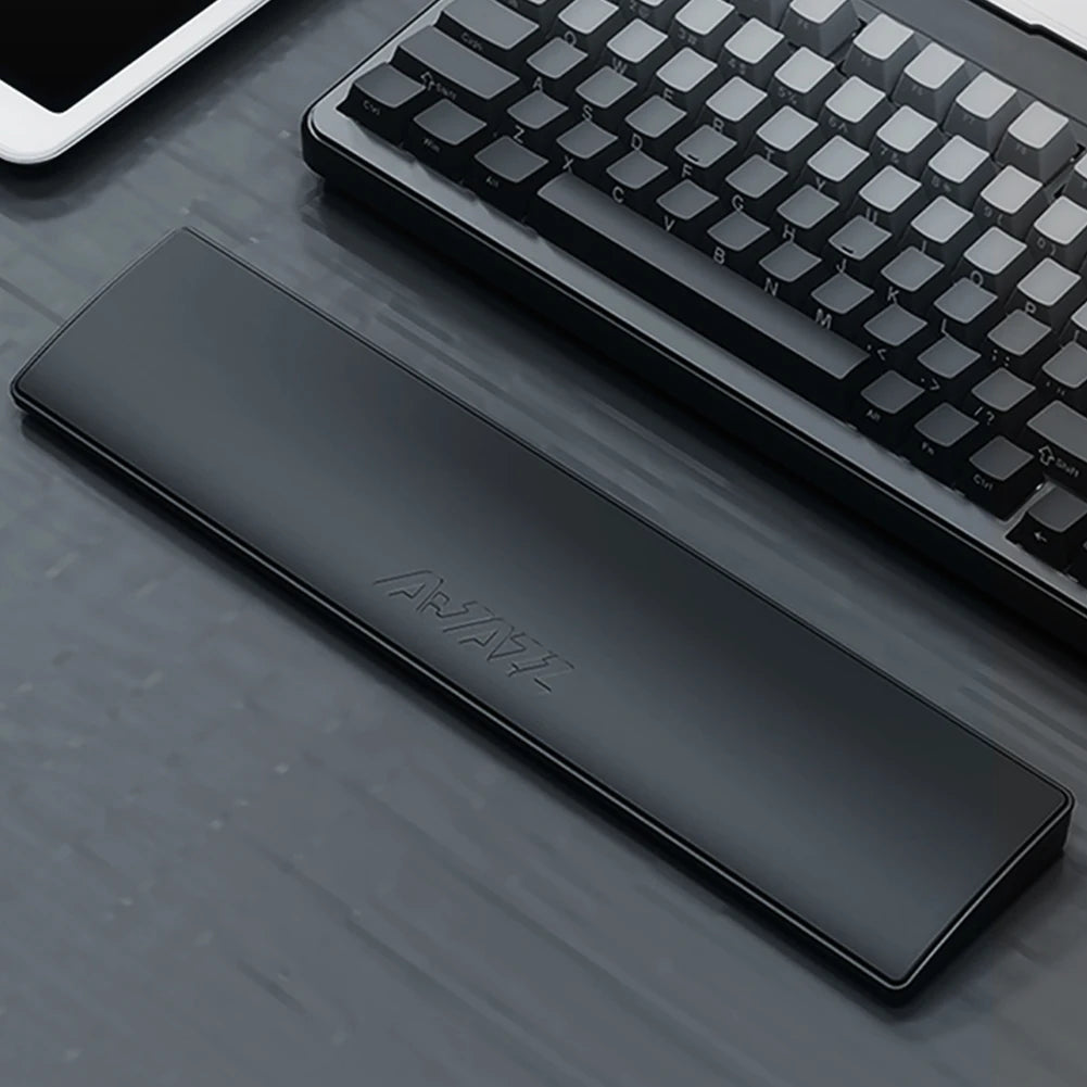Black wrist rest on a desk with a keyboard and tablet in the background