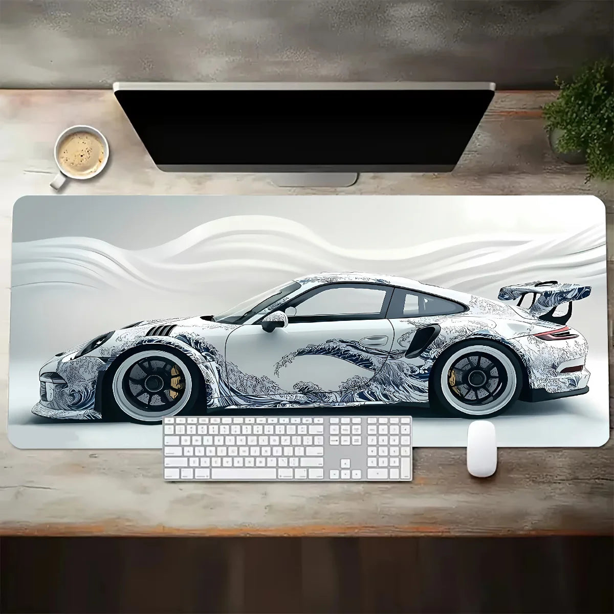 Desk setup with a large mouse pad featuring a car design, keyboard, and mouse.