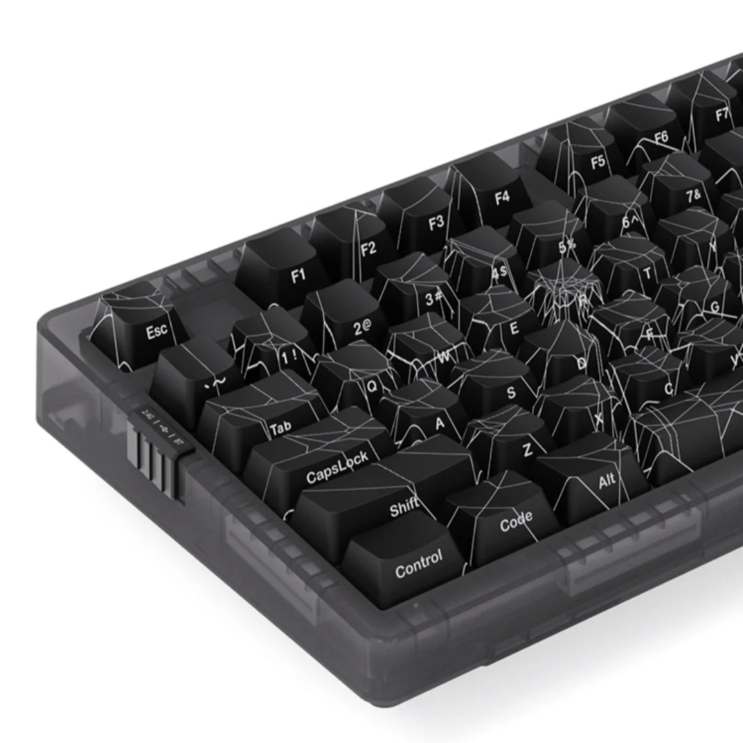 Black keyboard with spider web design on keys against a white background