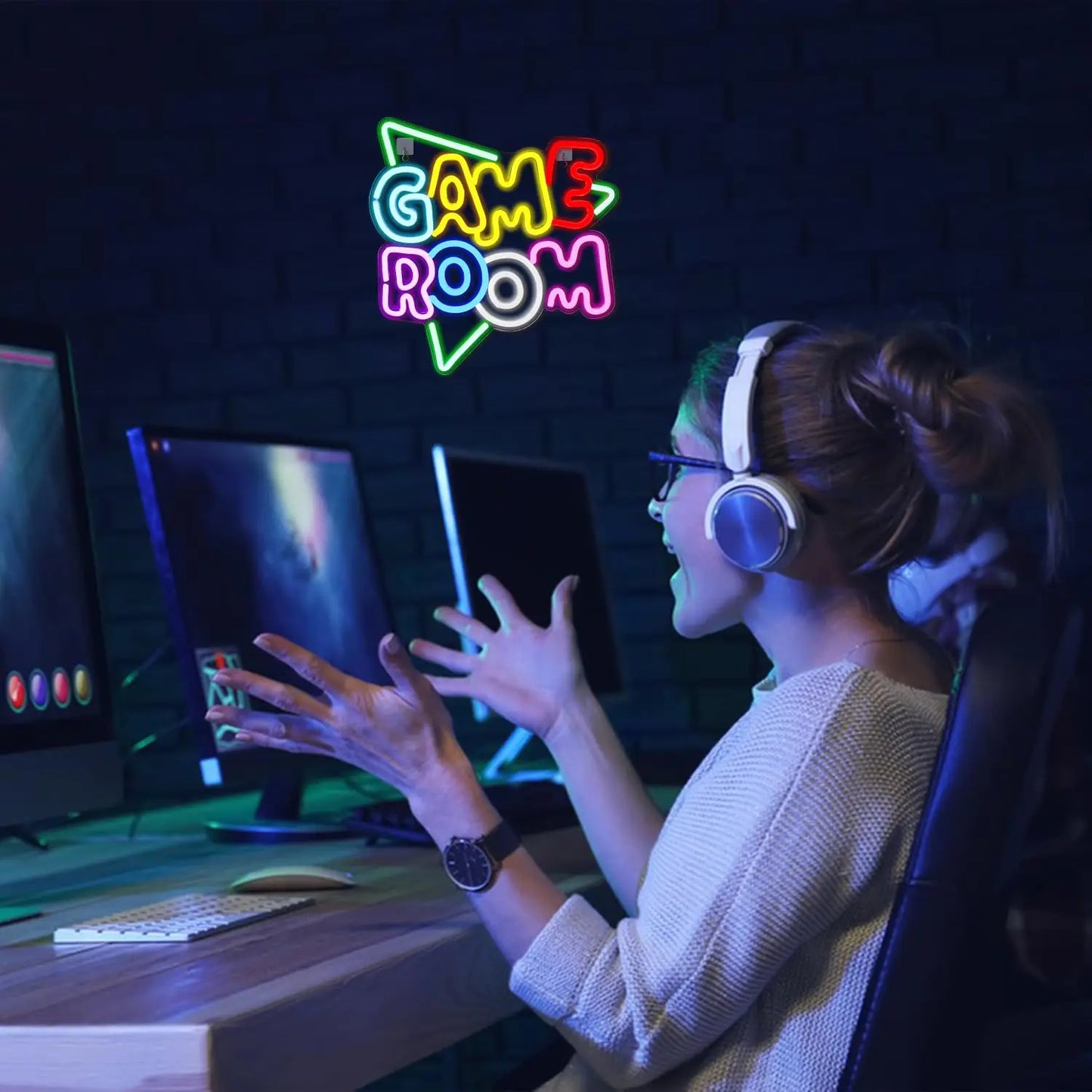 Person playing video games in a room with a neon 'Game Room' sign.