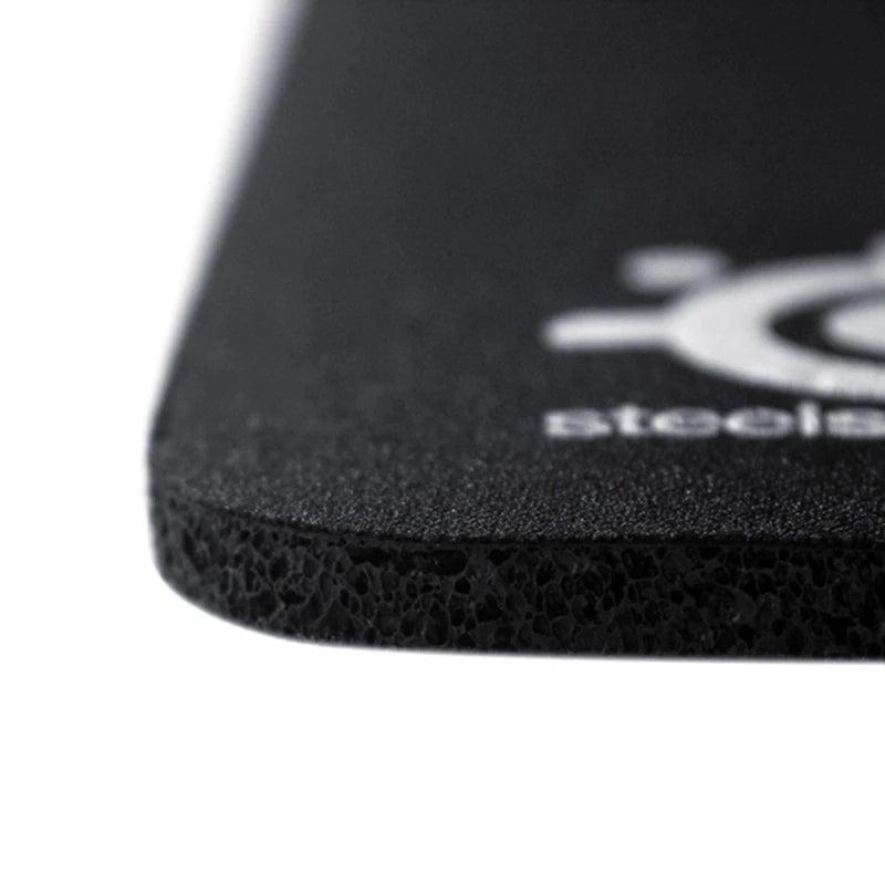 Close-up of a black mouse pad with a brand logo on a white background