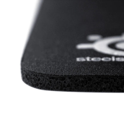 Close-up of a black mouse pad with a brand logo on a white background