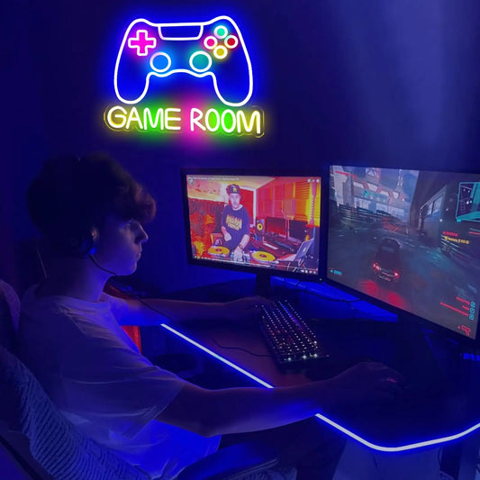 Person playing video games in a dark room with neon signs and multiple screens.