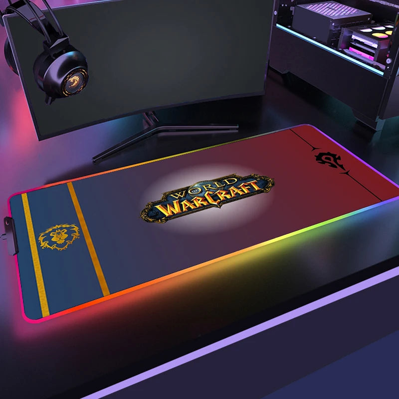 Gaming desk setup with a World of Warcraft mouse pad, monitor, and headphones.