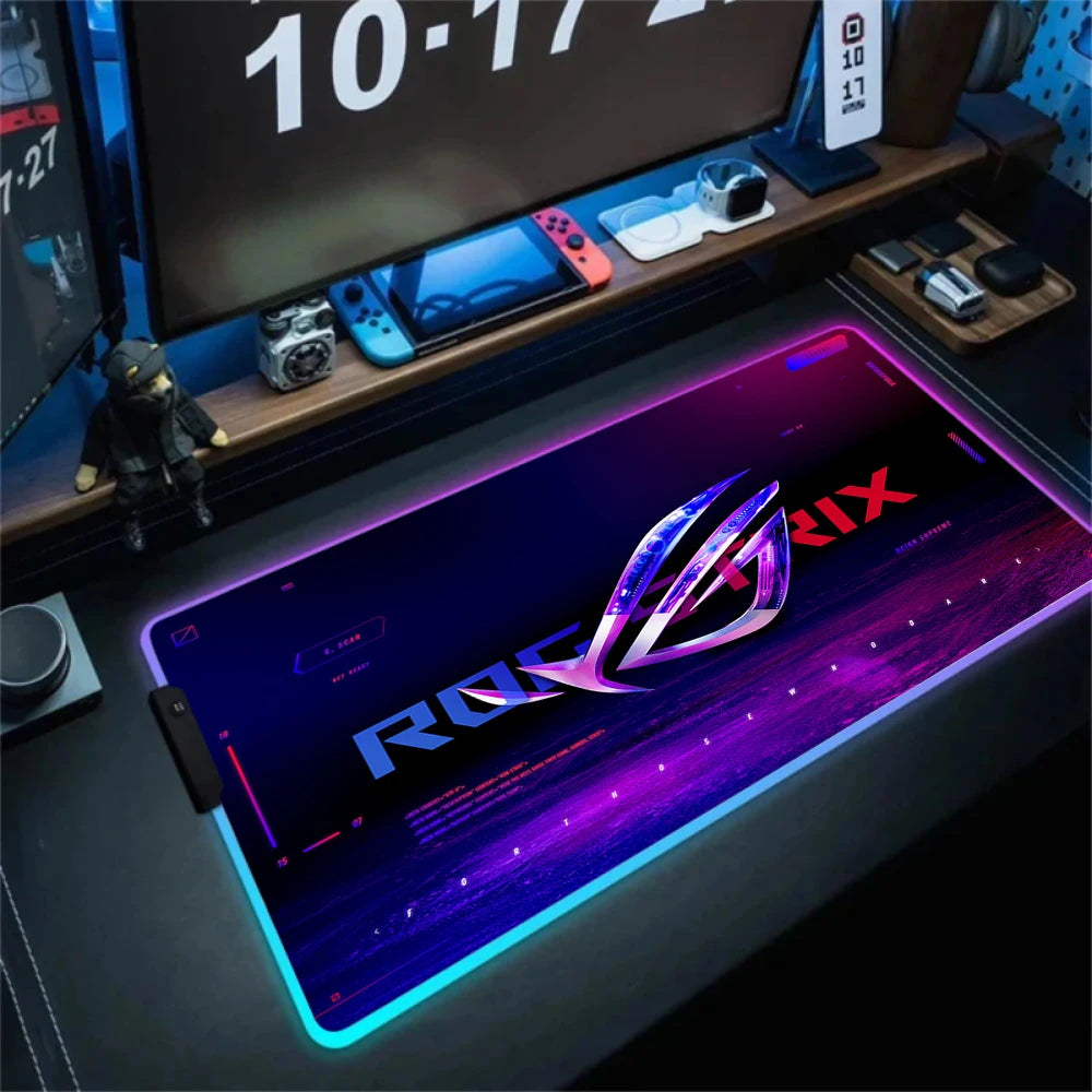 Gaming desk setup with a ROG (Republic of Gamers) mouse pad and computer equipment.