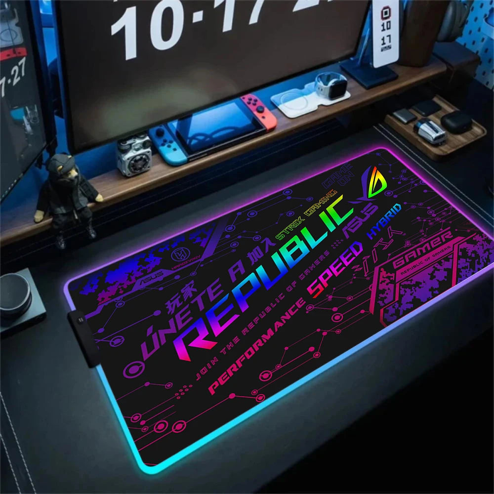 Gaming desk setup with a large mouse pad featuring colorful text and graphics.