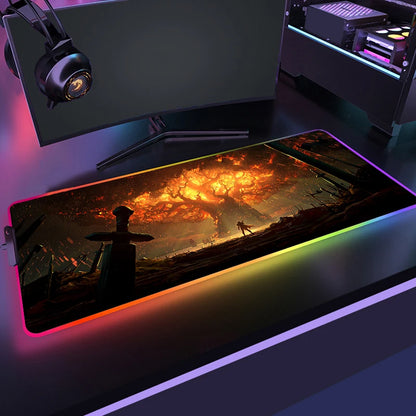 Gaming setup with a large mouse pad featuring a fiery landscape design, monitor, and headphones.