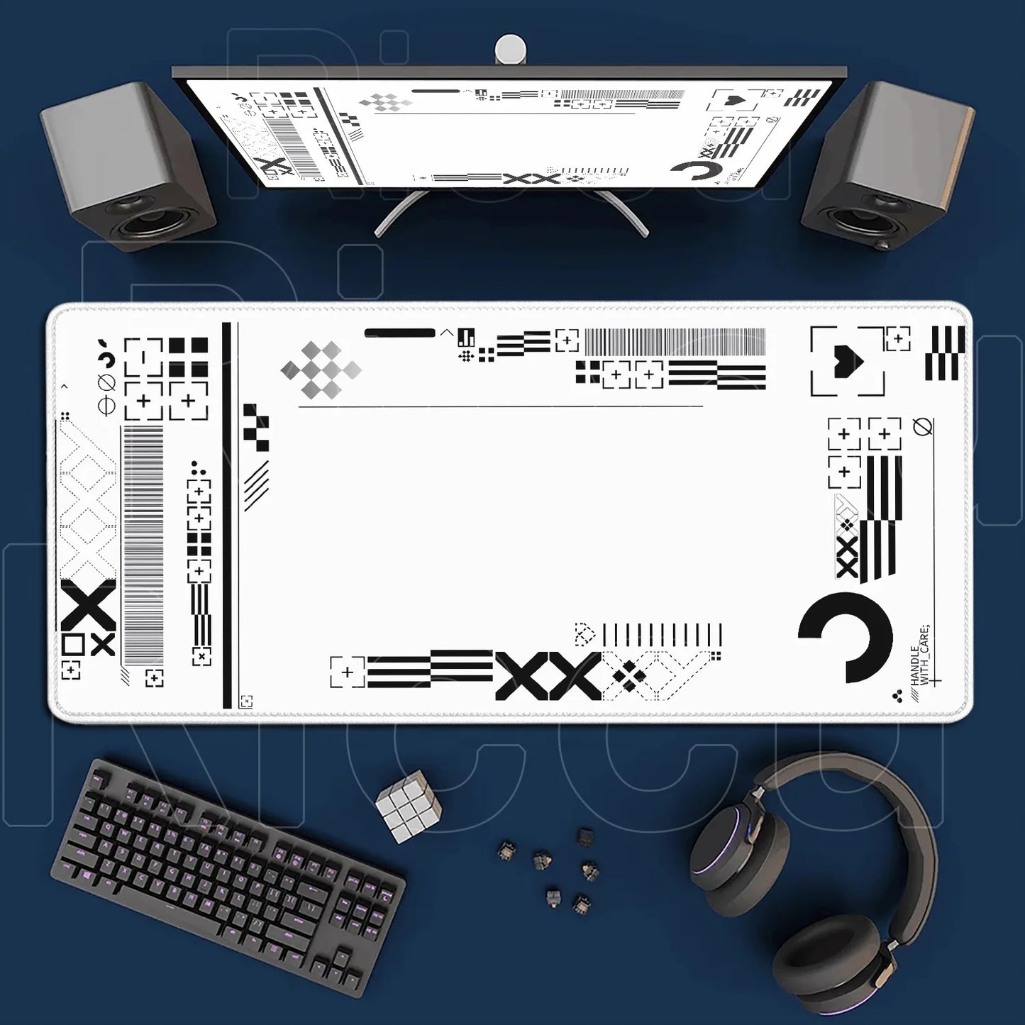 Desk setup with a monitor, keyboard, speakers, and headphones on a blue surface.