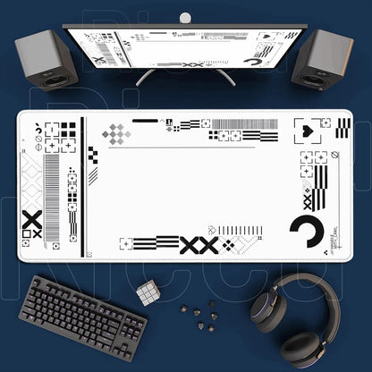 Desk setup with a monitor, keyboard, speakers, and headphones on a blue surface.