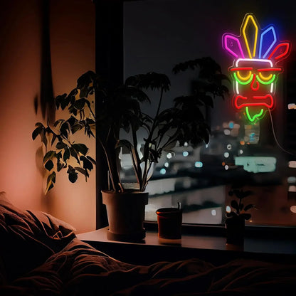 Neon sign of a face with a bone in a room with plants and a window view.