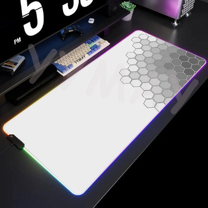 Gaming desk setup with a large mouse pad featuring a geometric pattern.