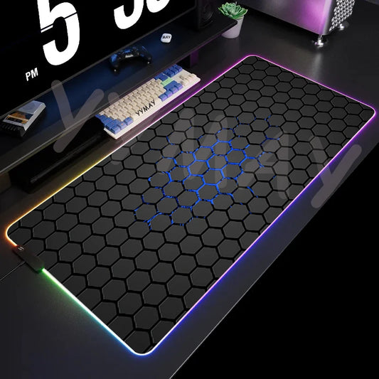 Gaming desk setup with a large mouse pad featuring a honeycomb pattern and RGB lighting.