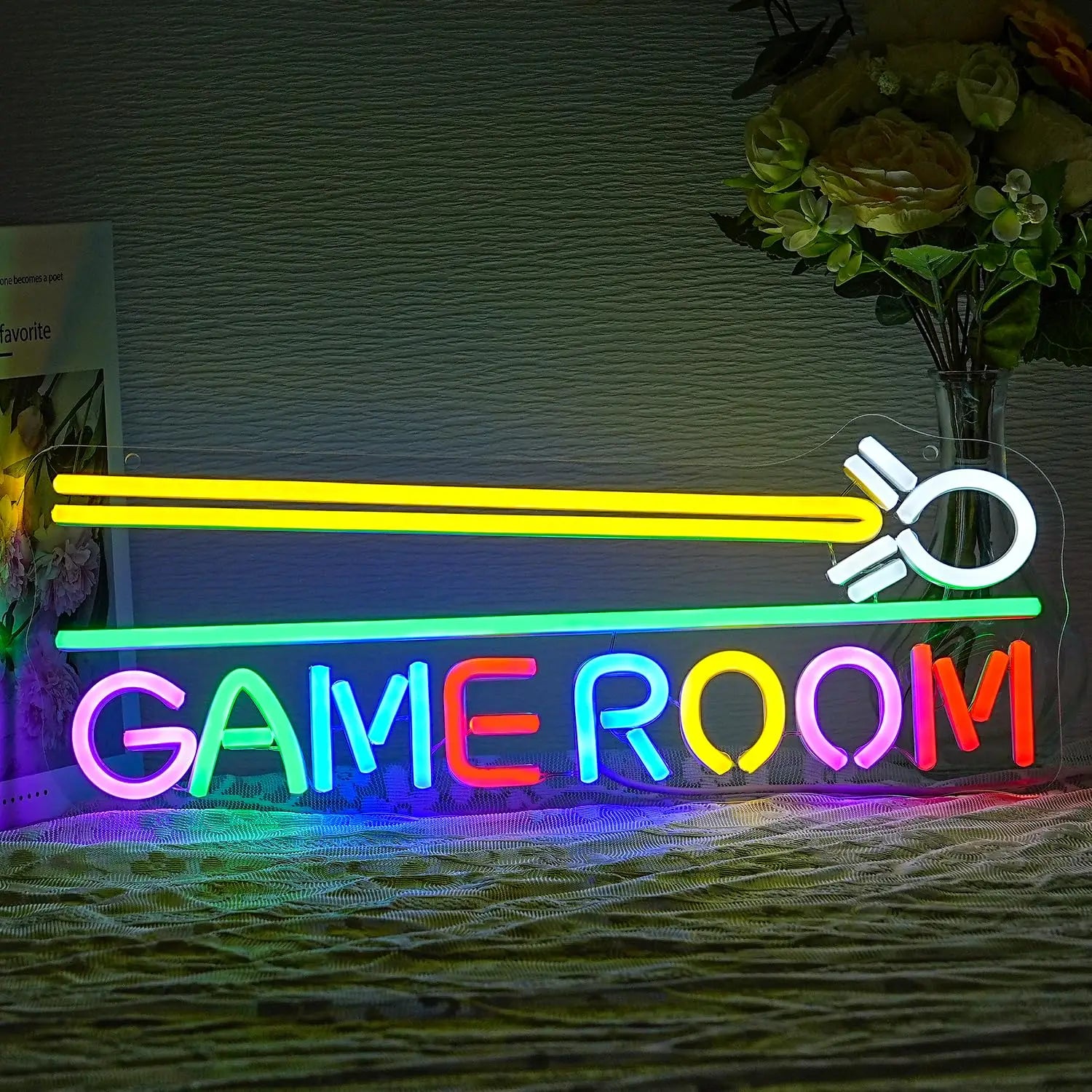 Neon sign with 'GAME ROOM' text and light saber design on a textured wall.