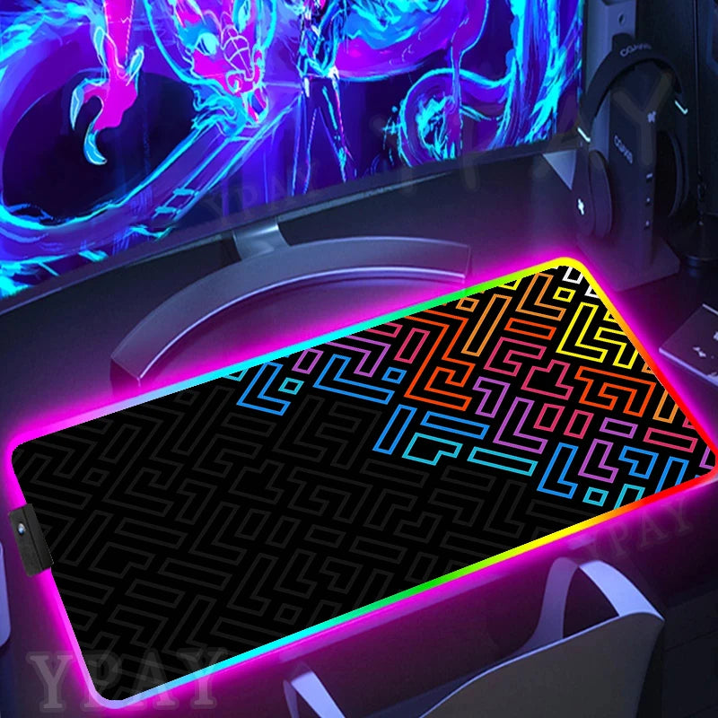 Gaming setup with a colorful LED mouse pad and monitor displaying vibrant graphics.