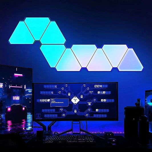 Neon lights shaped like a wave above a computer monitor in a dark room.
