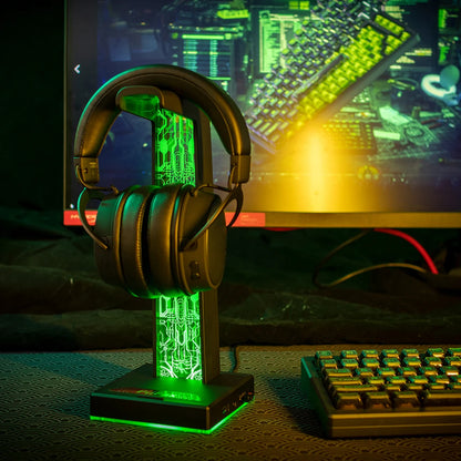 Headphones on a stand with a computer monitor displaying a cityscape in the background