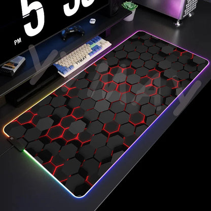 Gaming desk setup with a large hexagonal patterned mouse pad on a dark surface.