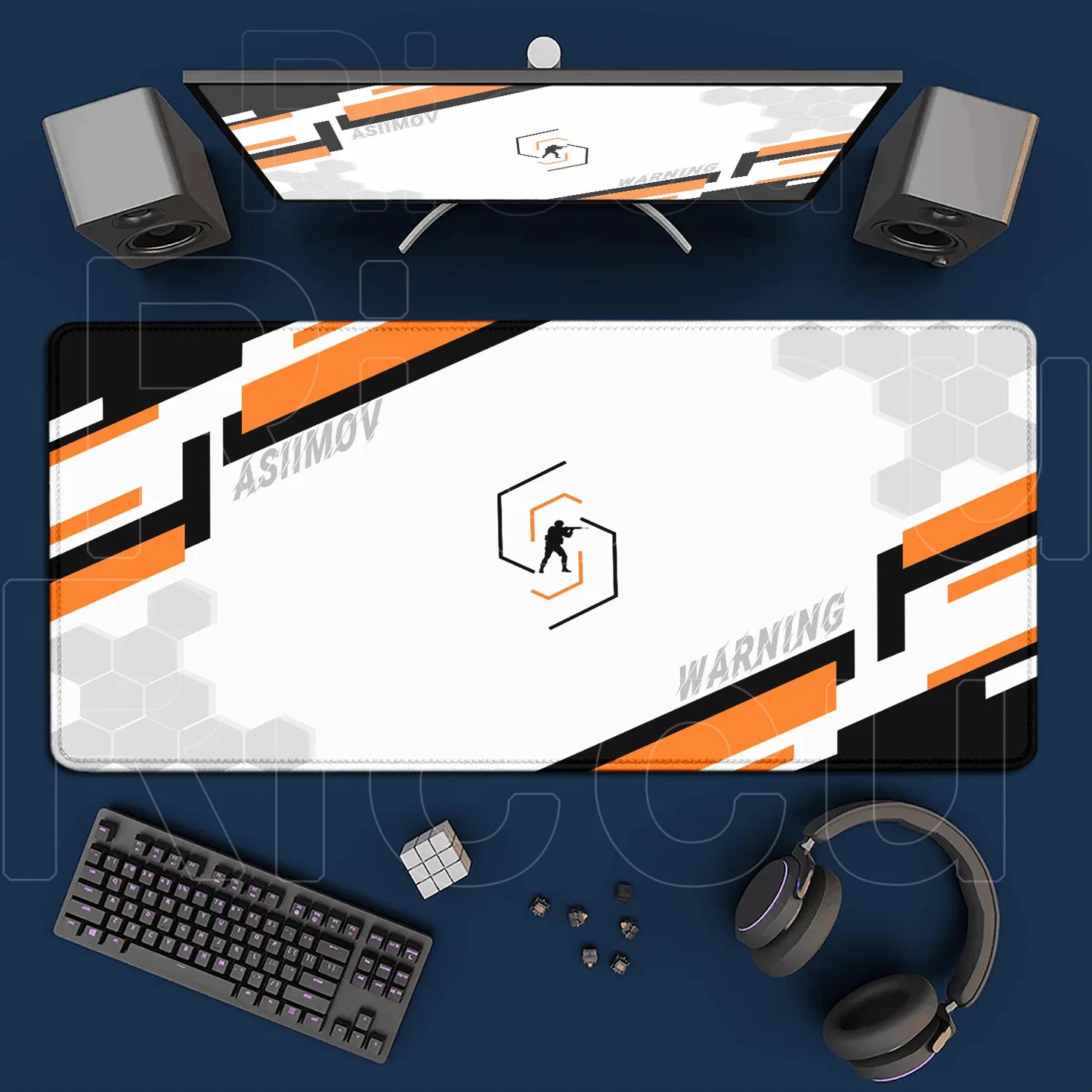 Gaming setup with monitor, mouse pad, keyboard, and headphones on a blue surface