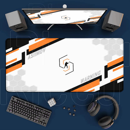Gaming setup with monitor, mouse pad, keyboard, and headphones on a blue surface