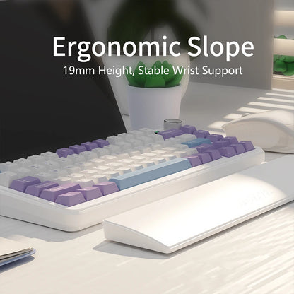 Ergonomic keyboard with text highlighting slope and wrist support on a desk.