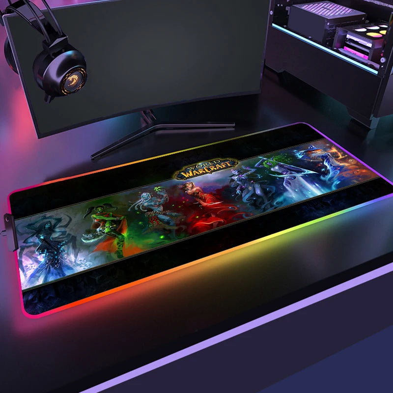 Gaming setup with a large mouse pad featuring colorful graphics, a monitor, and headphones on a desk.