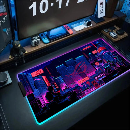 Gaming desk setup with a large mouse pad featuring a brand logo, surrounded by electronic devices.