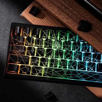 Glowing keyboard with spider web design on a dark surface