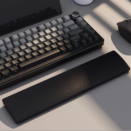 Mechanical keyboard and wrist rest on a desk with a neutral background