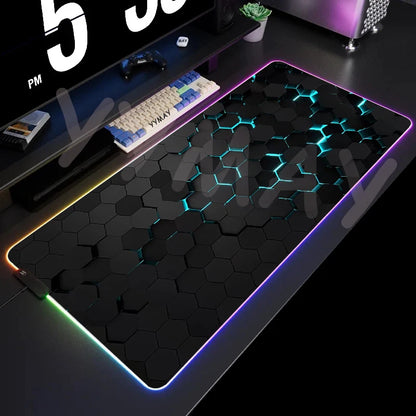 Gaming desk setup with a large mouse pad featuring a honeycomb pattern and RGB lighting.