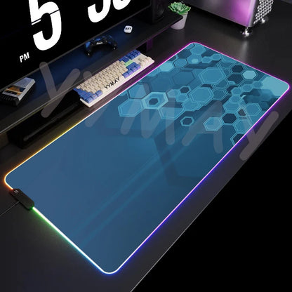 Gaming desk setup with a large mouse pad featuring geometric patterns and RGB lighting.