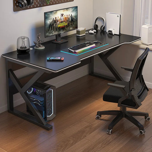 Gaming desk setup with monitor, keyboard, mouse, and chair in a room.