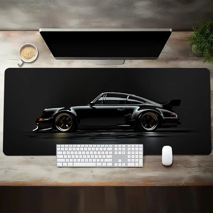 Black desk mat with a car design on a wooden desk with a computer setup.