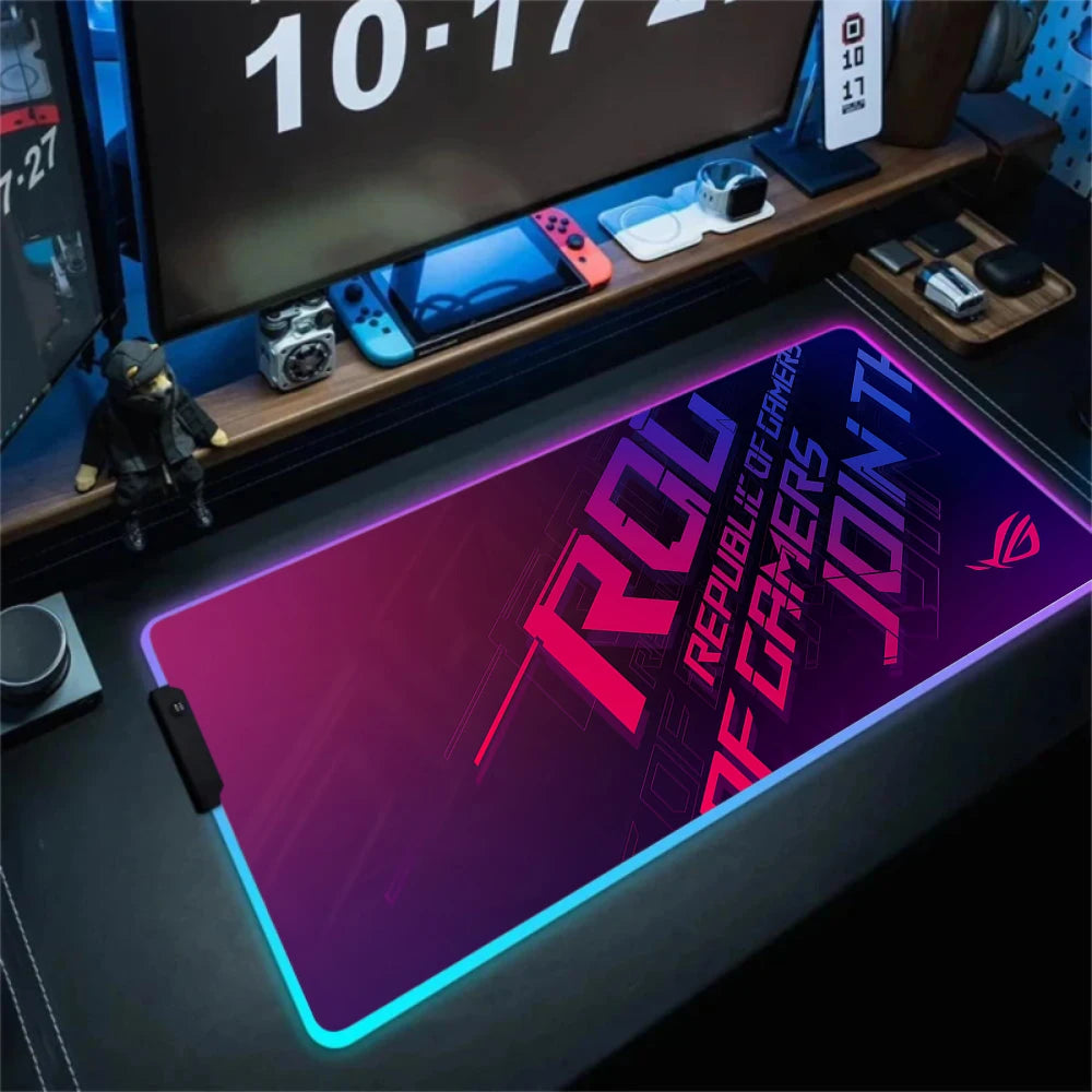 Gaming desk setup with a large mouse pad featuring ROG branding.