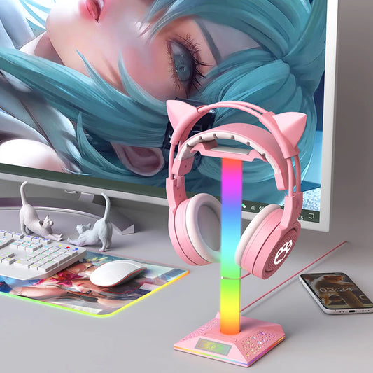 Pink headphones with cat ears on a colorful stand in front of a computer monitor.