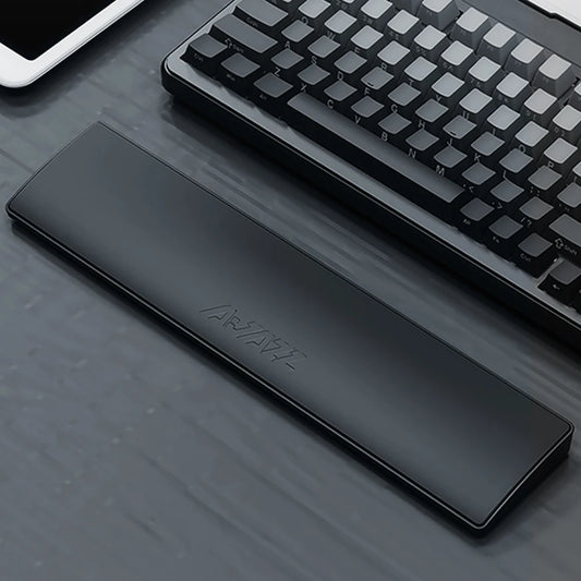 Black wrist rest on a desk with a keyboard and tablet in the background