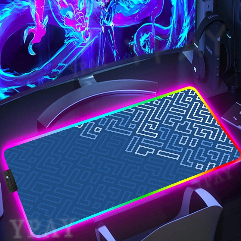 Gaming setup with a large mouse pad featuring a geometric pattern, illuminated by colorful lights.