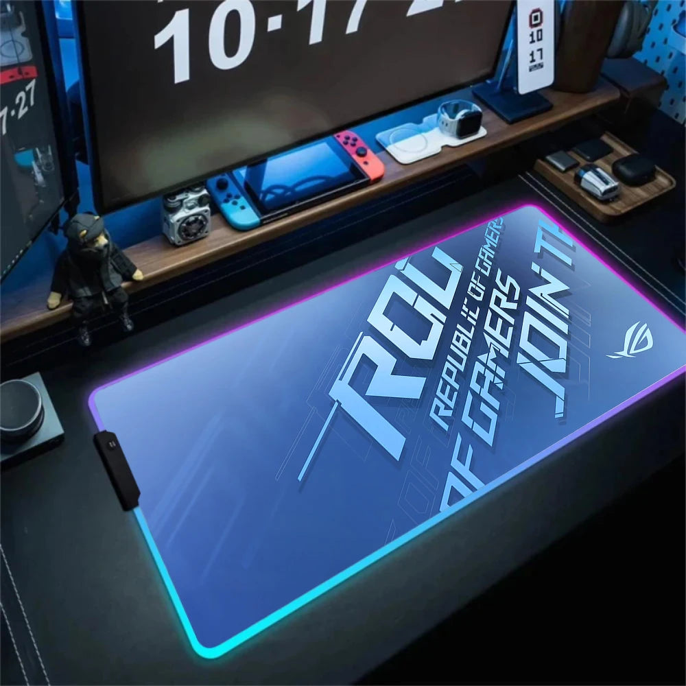 Gaming desk setup with a Republic of Gamers mouse pad and electronic devices.