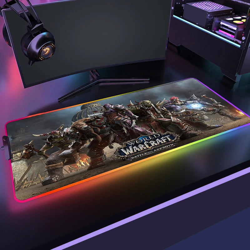 Gaming setup with a World of Warcraft mouse pad, monitor, and headphones on a dark surface.