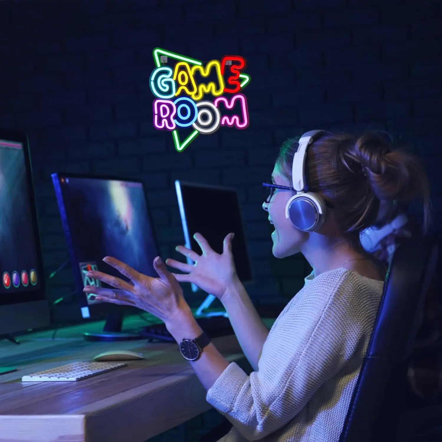 Person playing video games in a room with a neon 'Game Room' sign.