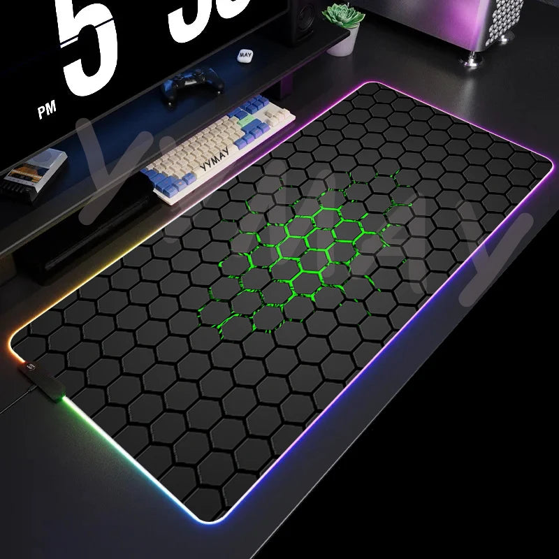 Gaming desk setup with a large mouse pad featuring a honeycomb pattern and RGB lighting.