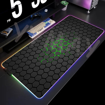 Gaming desk setup with a large mouse pad featuring a honeycomb pattern and RGB lighting.