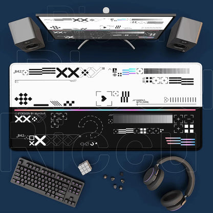 Computer setup with monitor, keyboard, headphones, and decorative mat on a blue surface