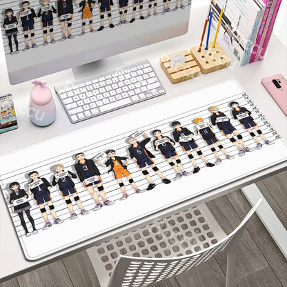 Desk setup with a large mouse pad featuring animated characters, keyboard, and monitor.
